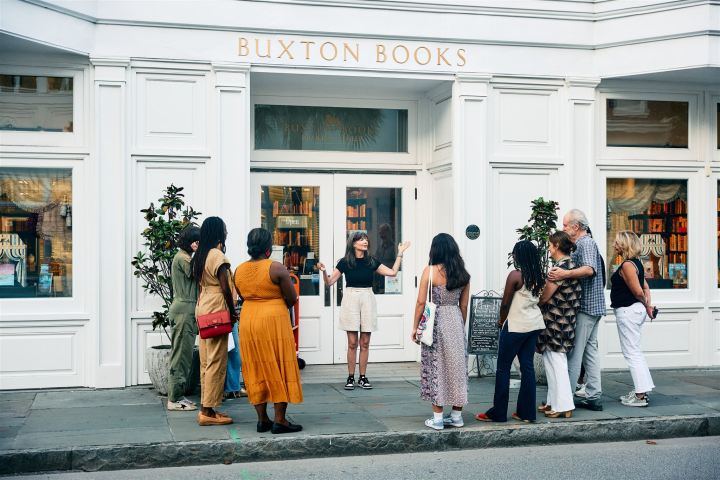 Woman speaking to a group outside Buxton Books store.