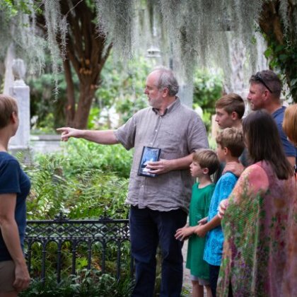 a group of people standing in front of a tree
